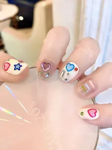 Detail of handmade Y2K press-on nails with 3D hearts, stars, and glitter rhinestones