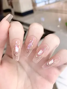 Macro shot of coffin-shaped press-on nails with seashell texture and gold frame
