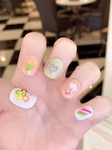 Détail de faux ongles faits main avec motifs 3D en relief de fleurs et de cœurs