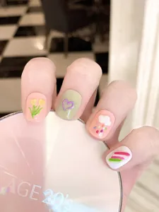 Détail de faux ongles 3D avec tulipes, cœurs et nuages dans des tons mats doux