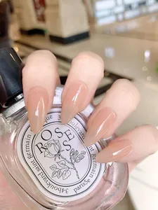 Macro detail of glossy nude almond-shaped press-on nails with a smooth jelly finish