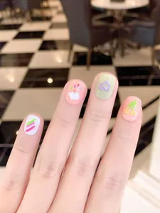 Détail de faux ongles faits main avec motifs mignons de nuages, de cœurs et de cerises