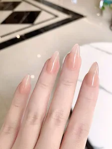 Macro detail of almond-shaped translucent nude pink press-on nails with a glossy finish