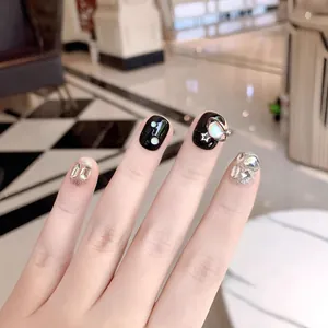 Unghie finte artigianali nere e glitterate argento con ciondoli a pianeta e strass