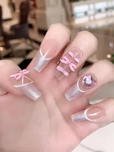 Detail showing 3D pink bow and heart rhinestone on ballerina press-on nails with silver glitter