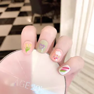 Faux ongles faits main avec motifs de tulipes et de cœurs peints dans des tons pastel
