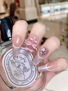 Detail of pink heart gemstone and bow decoration on long ballerina press-on nails