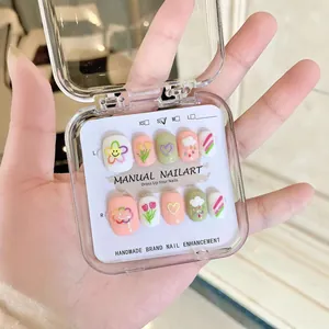 Faux ongles faits main avec fleurs 3D, cœurs et motifs arc-en-ciel aux tons macaron