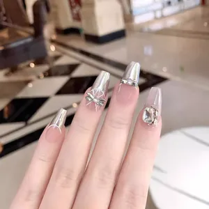 Silver metallic press-on nails with 3D crystal bows and pearls in a ballet shape