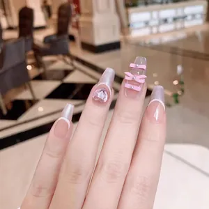Pink press-on ballerina nails with 3D crystal bows, heart rhinestones and pearl accents