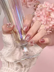 Detailed close-up of handmade press-on nails with purple cat eye glitter and 3D butterfly