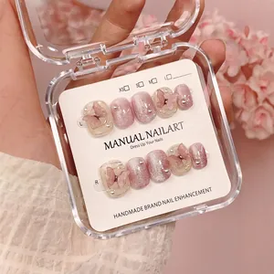 Handmade press-on nails featuring pink cat eye effect with 3D butterfly and pearl accents