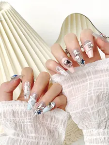 Macro detail of long trapezoid press-on nails with blue rhinestones and silver glitter