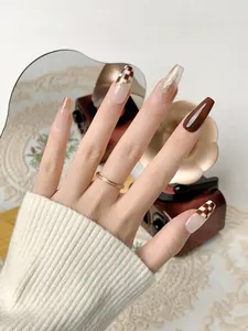 Detail of long coffin press-on nails with brown checkerboard and gold foil accents