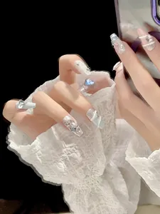 Detail shot of blue long coffin handmade press-on nails with 3D rhinestones and pearls