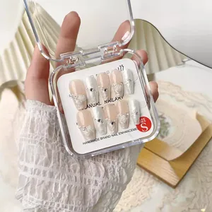 Faux ongles faits main rose poudré et blanc nacré avec fleurs 3D et perles élégantes