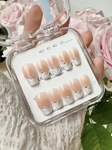 Detail of nude pink gradient press-on nails with white marble tips and pearl accents