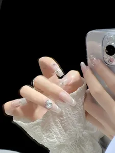 Detailed macro of coffin press-on nails with nude pink gradient and luxury silver rhinestones