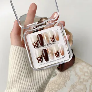 Handmade press-on nail set featuring amber checkerboard and caramel gold foil designs