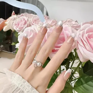 Elegant French press-on nails with pink blush gradient and sparkling rhinestone accents