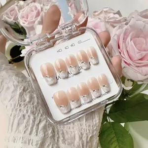 Handmade press-on nails with pearl and rhinestone accents in a soft gradient design