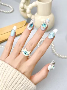Close-up of blue bow press-on nails with 3D monster ring and pearl jewelry details