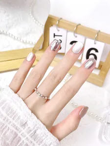 Dettaglio di unghie cat-eye argento con accenti metallici 3D e anello di perle