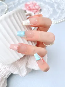 Macro detail of handmade press-on nails with 3D hearts, pearls and rhinestones decoration