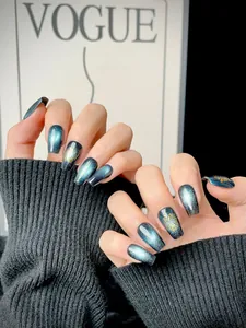 Close-up of long trapezoidal press-on nails with blue cat-eye effect and star patterns