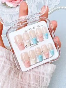 Detail of handmade press-on nails with 3D hearts and pearls in a clear display box