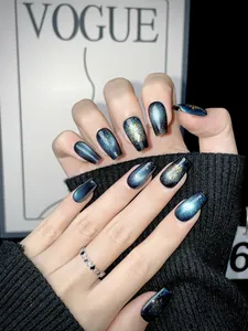 Detailed view of dark blue cat eye press-on nails with golden snowflake art and coffin shape