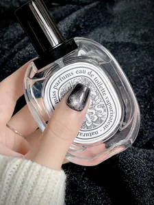 Gros plan sur des ongles press-on dégradés pailletés argent et noir effet œil de chat