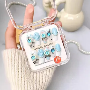 Handmade light blue press-on nails set with 3D bows and cat ear details in a gift box