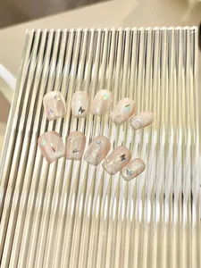 Detail of short square nude pink press-on nails with glitter and laser butterfly accents