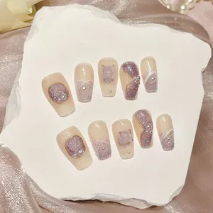 Handmade lavender cat-eye press-on nails with butterfly charms and pearl accents