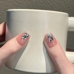 Faux ongles faits main dégradé rose nude avec paillettes argentées et strass 3D