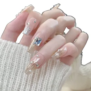 Sparkly handmade press-on nails with rhinestones and glitter in a long coffin shape