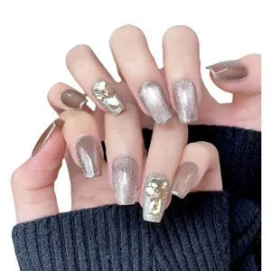 Handmade cat-eye press-on nails with luxury rhinestones and glitter in brown and gold