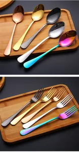 Primer plano de cubiertos de acero inoxidable multicolor con tenedores y cucharas pulidos