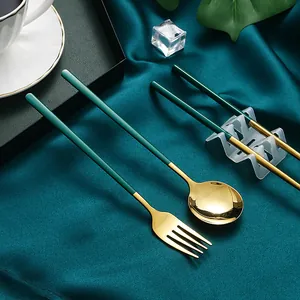 304 Edelstahl-Besteckset mit Goldköpfen und mattgrünen Griffen auf blauem Seidenstoff