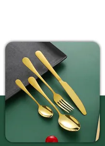 Macro view of gold stainless steel cutlery set with mirror finish on dark plate