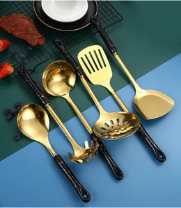 Close-up of gold stainless steel kitchen utensil set with black marble handle textures