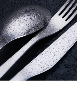 Makro-Detail von gebürstetem 304 Edelstahl-Besteckset mit sauberen Wassertropfen
