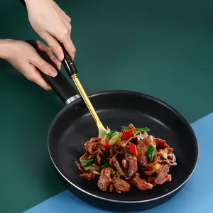 Nordic stainless steel golden spatula with black handle used in a non-stick frying pan