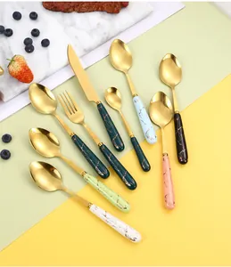 Detail of 24-piece stainless steel cutlery set with marble texture handles and gold finish