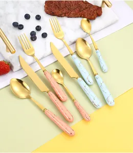 Detail of pink and blue marble handle cutlery set with gold stainless steel finish