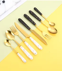 Detail view of gold stainless steel cutlery set with marble texture ceramic handles