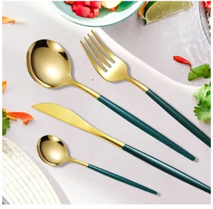 Detailed close-up of green and gold stainless steel cutlery set with elegant matte handles