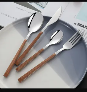 Close-up of four-piece stainless steel cutlery set with elegant wood grain handles