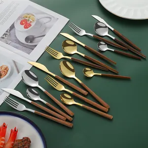 24-piece stainless steel cutlery set with wood grain handles on elegant green background